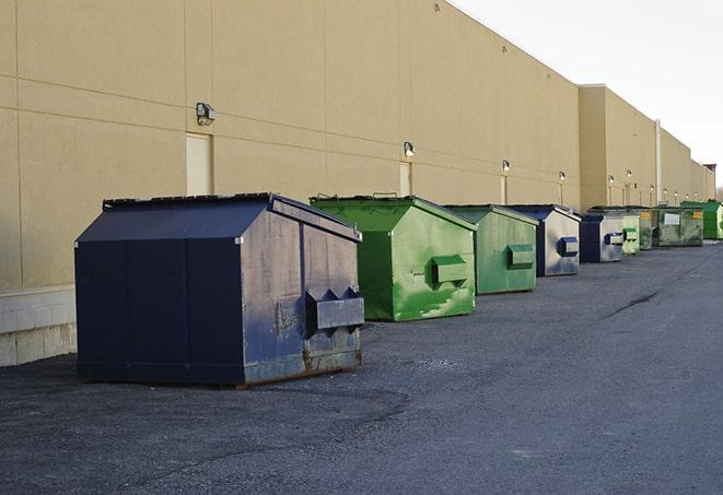 construction workers throw waste into a dumpster behind a building in Bargersville, IN